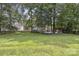 Expansive backyard with lush green lawn, mature trees, and deck areas at 9954 Mitchell Glen Dr, Charlotte, NC 28277
