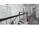 Bright hallway with dark wood floors and black and white staircase at 9954 Mitchell Glen Dr, Charlotte, NC 28277