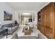 Inviting living room featuring hardwood cabinets, a gray sofa, and decorative artwork at 9954 Mitchell Glen Dr, Charlotte, NC 28277