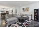 Spacious living room featuring a gray sectional sofa, modern decor, and hardwood floors at 9954 Mitchell Glen Dr, Charlotte, NC 28277