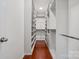 Walk-in closet features custom shelving and hardwood floors at 10009 Community House Rd, Charlotte, NC 28277