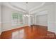 Elegant dining room with hardwood floors, large window, and stylish light fixture at 10009 Community House Rd, Charlotte, NC 28277