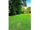 Beautiful green lawn surrounded by mature trees, offering a tranquil and natural setting at 114 Huffstetler Rd, Gastonia, NC 28056