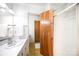 Bathroom with a white sink vanity, mirror, and a wooden door to the shower at 114 Huffstetler Rd, Gastonia, NC 28056