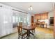 Dining room adjacent to kitchen features green carpet, round wood table and ample natural light at 114 Huffstetler Rd, Gastonia, NC 28056