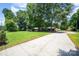 Expansive property with a long driveway leading to a charming, one-story brick home surrounded by mature trees at 114 Huffstetler Rd, Gastonia, NC 28056