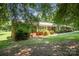 A beautiful, one-story brick home boasts a well-maintained yard and is framed by mature trees at 114 Huffstetler Rd, Gastonia, NC 28056