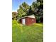 Charming brick outbuilding with a white door on a spacious lawn surrounded by mature trees at 114 Huffstetler Rd, Gastonia, NC 28056