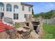 Backyard featuring an outdoor kitchen area with a stone grill and a seating area with metal chairs at 12004 New Bond Dr, Huntersville, NC 28078