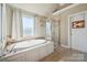 Bathroom featuring a soaking tub, glass shower, and tiled floors at 12004 New Bond Dr, Huntersville, NC 28078