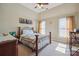 Cozy bedroom featuring a bed with metal frame, ceiling fan, and ample natural light from two windows at 12004 New Bond Dr, Huntersville, NC 28078