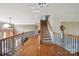 Bright hallway featuring hardwood floors, a staircase to the second floor, and a wrought iron railing at 12004 New Bond Dr, Huntersville, NC 28078