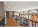 Hallway featuring wood floors, iron railings, and a view into the living room below at 12004 New Bond Dr, Huntersville, NC 28078