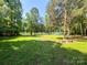 Grassy lawn and lake overlook with mature trees and community BBQ at 12004 New Bond Dr, Huntersville, NC 28078