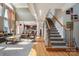 Bright, open-concept living room with staircase, wood floors, and view into the kitchen at 12004 New Bond Dr, Huntersville, NC 28078
