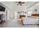 Large main bedroom featuring a ceiling fan, carpeted floors, and ensuite bathroom entrance at 12004 New Bond Dr, Huntersville, NC 28078