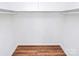 Spacious walk-in closet with wood-style floors and white walls with rod and shelf at 1300 Queens Rd # 405, Charlotte, NC 28207