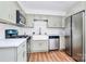 Updated kitchen with stainless steel appliances, white cabinets, and a farmhouse sink at 1300 Queens Rd # 405, Charlotte, NC 28207