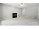 Neutral living room boasts a classic fireplace, ceiling fan, and access to adjoining rooms at 14658 Laura Michelle Rd, Huntersville, NC 28078
