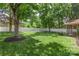 A spacious backyard featuring a well-maintained lawn, mature trees, and a white picket fence at 14747 Pomerol Ln, Pineville, NC 28134