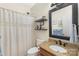 Updated bathroom featuring shower curtain, granite vanity and decorative shelves at 14747 Pomerol Ln, Pineville, NC 28134