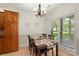 Bright dining area with a dark wood table set for six in front of a large window at 14747 Pomerol Ln, Pineville, NC 28134