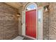 Close-up of a vibrant red front door framed by brick, sidelights, and a classic arched transom window at 14747 Pomerol Ln, Pineville, NC 28134