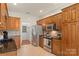 Bright kitchen featuring stainless steel appliances, wooden cabinetry, and stone countertops at 14747 Pomerol Ln, Pineville, NC 28134