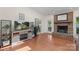 Bright living room with hardwood floors, a brick fireplace, and a entertainment center near an open doorway at 14747 Pomerol Ln, Pineville, NC 28134