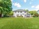 Large, well-manicured backyard featuring a lush lawn, perfect for outdoor activities, and complete with a pergola and fire pit at 1605 Ambergate Dr, Waxhaw, NC 28173