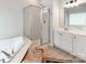 Bright bathroom featuring a glass-enclosed shower, soaking tub, and double vanity at 1605 Ambergate Dr, Waxhaw, NC 28173