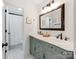 Bathroom featuring a double vanity with decorative tiling, framed mirror, and separate shower area at 1605 Ambergate Dr, Waxhaw, NC 28173
