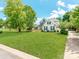 Beautiful white brick home with a spacious front yard, mature trees, and a long driveway at 1605 Ambergate Dr, Waxhaw, NC 28173
