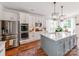 Kitchen with large island, white cabinets, stainless appliances, and hardwood floors at 1605 Ambergate Dr, Waxhaw, NC 28173