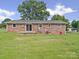 View of the exterior brick facade with a sliding glass door and lush lawn at 197 Horseshoe Loop, Statesville, NC 28625