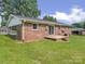 Back exterior view of a brick house with a covered patio, and green lawn at 197 Horseshoe Loop, Statesville, NC 28625