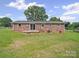 View of the exterior brick facade with a sliding glass door and lush lawn at 197 Horseshoe Loop, Statesville, NC 28625