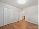 Bright bedroom features wood-look floors, neutral walls, and closet with double doors at 197 Horseshoe Loop, Statesville, NC 28625