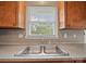 Bright kitchen showcasing a stainless steel sink and wood cabinets under a sunlit window at 197 Horseshoe Loop, Statesville, NC 28625