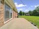 View of the patio with sliding glass door, brick exterior, and a green lawn at 197 Horseshoe Loop, Statesville, NC 28625