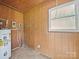 Utility area featuring wood paneling, water heater, and a window for ventilation at 197 Horseshoe Loop, Statesville, NC 28625