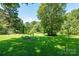 Expansive backyard with lush lawn and mature trees, providing a serene and private outdoor setting at 2008 Kimway Dr, Matthews, NC 28105
