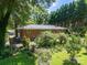 Lush backyard featuring a brick home, mature trees and manicured landscaping at 2008 Kimway Dr, Matthews, NC 28105