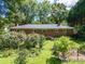 Brick home with beautiful, lush backyard with many trees and flower garden at 2008 Kimway Dr, Matthews, NC 28105
