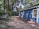 Side view of the blue home featuring a spacious backyard with a small storage shed and lots of potential at 218 Hartman St, Gastonia, NC 28052