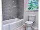 Stylish bathroom features a tiled shower-tub combination and modern toilet, offering a clean design at 218 Hartman St, Gastonia, NC 28052