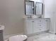 Bathroom featuring double vanity, granite countertop, and a sleek toilet on elegant marble flooring at 218 Hartman St, Gastonia, NC 28052