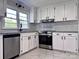 Bright kitchen features white cabinets, subway tile backsplash, stainless steel appliances, and granite countertops at 218 Hartman St, Gastonia, NC 28052