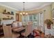 A dining room features a modern table and chairs, a chandelier, and large windows at 2256 Drawbridge Ct, Rock Hill, SC 29732