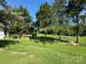 Fenced backyard with mature trees and a shed in the distance at 22987 Alonzo Rd, Oakboro, NC 28129